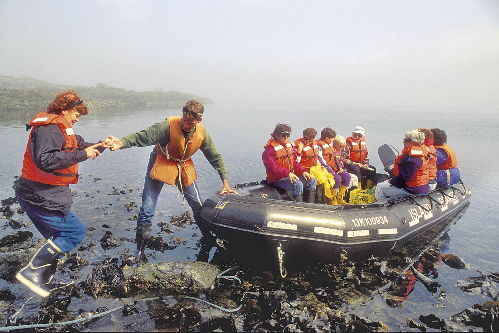 A historic photo of Bluewater guests being helped ashore by crew